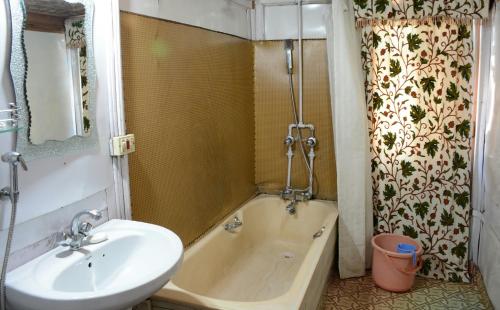 斯利那加Houseboat Zaindari Palace的浴室设有水槽和水槽旁的浴缸
