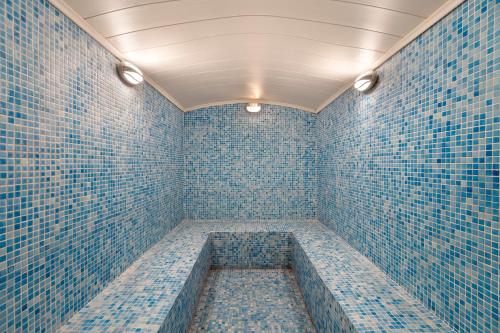 马赫姆拉Euphoria Comfort Beach Alanya的客房设有蓝色瓷砖墙壁和浴缸。