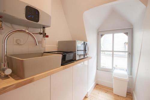布尔日LE COURSARLON的白色的厨房配有水槽和微波炉