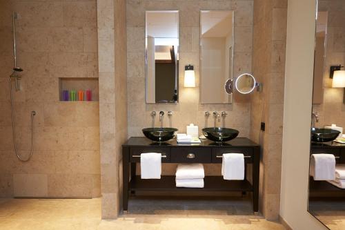 慕尼黑DO & CO Hotel München的一间带两个盥洗盆和淋浴的浴室