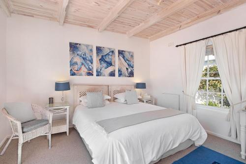 Tokai晨畔小屋宾馆的白色的卧室设有一张大床和一个窗户