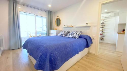 罗萨斯Acapulco b5的一间卧室配有一张带蓝色棉被的床