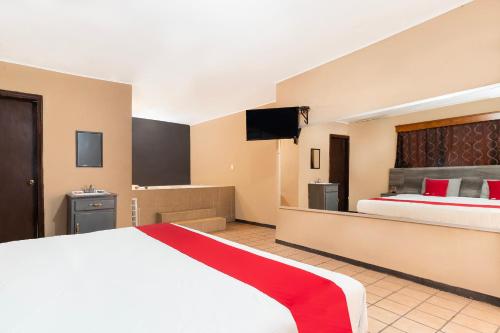 奇瓦瓦OYO Hotel Real Del Sur, Estadio Chihuahua的配有一张床和一台平面电视的酒店客房