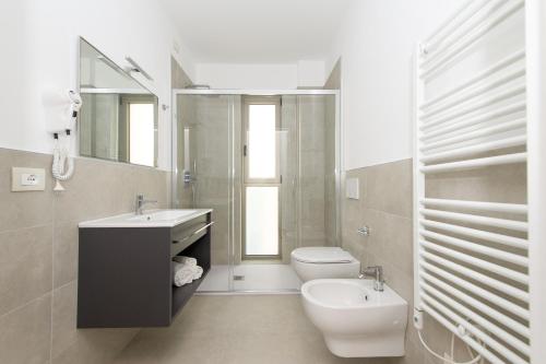 格拉多Ariston Teatro Luxury Aparthotel的一间带水槽、卫生间和镜子的浴室