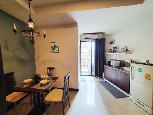 曼谷552 Residence的厨房以及带桌子和冰箱的用餐室