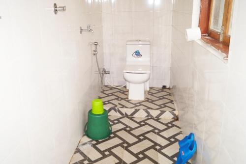 大吉岭Yumasham Homestay的铺有瓷砖地板,设有带卫生间的浴室