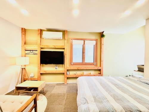东京池袋Apila的一间卧室设有一张床、一台电视和一个窗口。