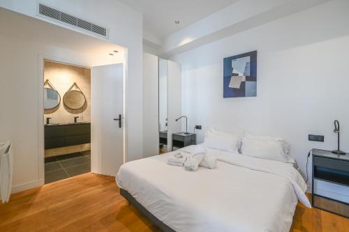巴黎Appartement de Prestige - Grand Varenne的一间带白色床的卧室和一间浴室