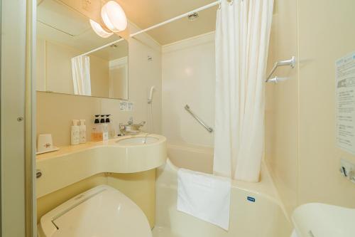 东京Kanda Station Hotel的浴室配有卫生间、盥洗盆和淋浴。