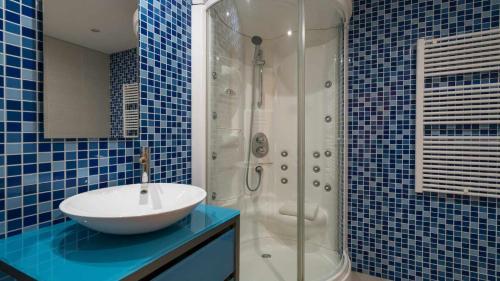 奎特里拉Marina Vilamoura Aquamar 220 By Vilamoura Sun的蓝色瓷砖浴室设有水槽和淋浴