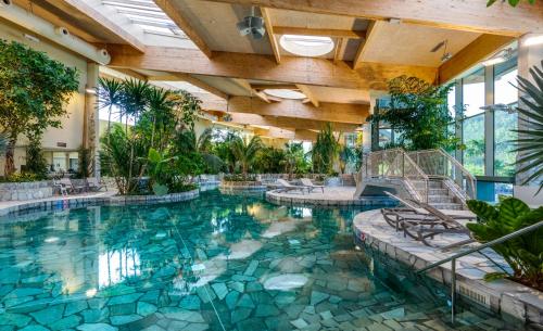迪尔森-斯托科姆Terhills Resort by Center Parcs的一座种植了树木和植物的建筑中的游泳池