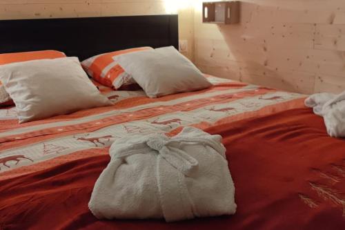FrémifontaineChez Laurette的一张带橙色毯子和白色枕头的床