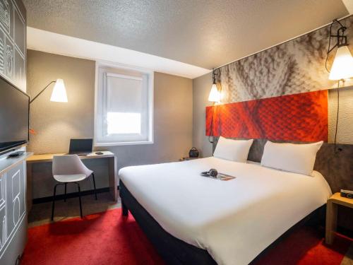 沙朗通勒蓬巴黎博泰贝西宜必思酒店的酒店客房设有一张白色大床和一张书桌