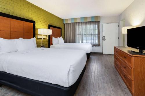 坦帕La Quinta Inn Tampa Airport Stadium Westshore的酒店客房设有两张床和一台平面电视。