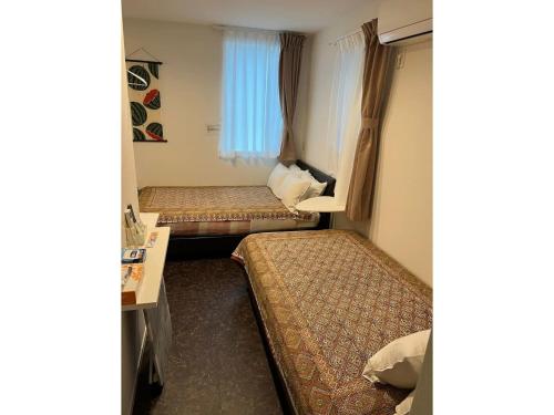 东京Tokyo stay Hut SARI - Vacation STAY 27239v的客房设有两张床和一张书桌