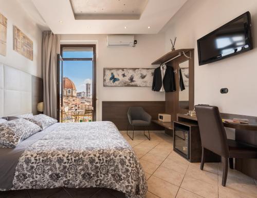 佛罗伦萨贝拉维斯塔酒店的一间卧室配有一张床、一张书桌和一个窗户。
