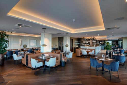 卡德赞德-班得斯海尔德酒店的一间带桌椅的餐厅和一间酒吧