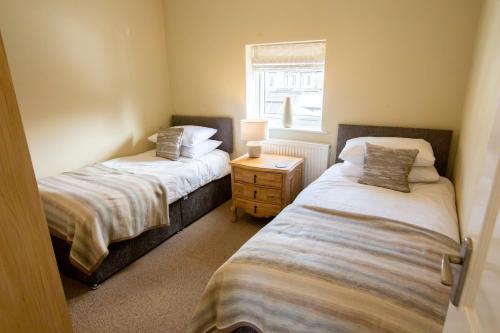 莱瑟姆-圣安妮Mulberry Cottage - Cosy 3 Bed Cottage near Lytham Windmill的带窗户的客房内设有两张单人床。