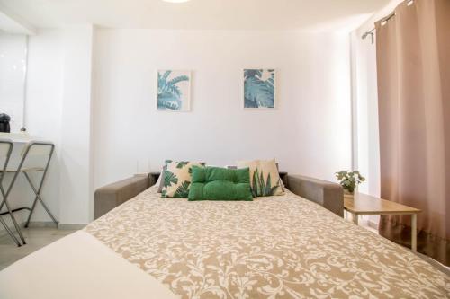 多列毛利诺斯Erisa 55 by IVI Real Estate的一间卧室配有一张带绿色枕头的大床