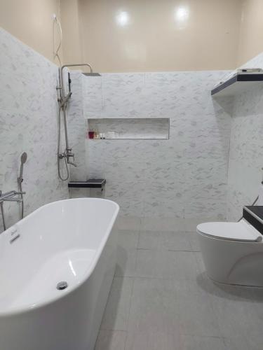 第波罗B&S Orchids suites hotel的白色的浴室设有浴缸和卫生间。