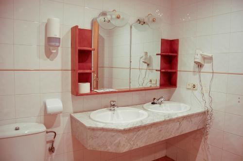 特拉加塞特埃尔加莫酒店的浴室设有2个水槽、镜子和卫生间。