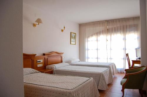 特拉加塞特埃尔加莫酒店的酒店客房设有两张床和窗户。