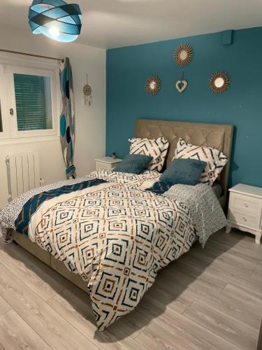 图勒Chez Julie petit appartement une chambre rez jardin maison的一间卧室配有一张带蓝色墙壁的大床