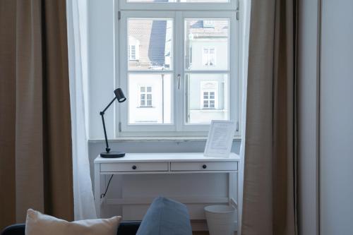 奥格斯堡Maximilianstraße的窗户前方配有带台灯的书桌