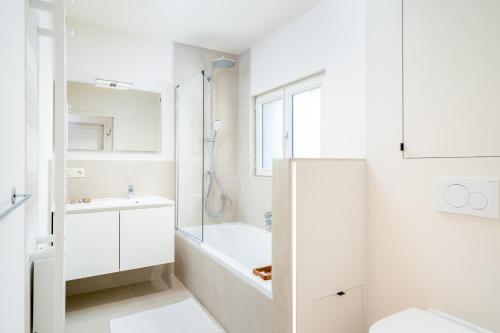 克诺克－海斯特CAPRINO Guesthouse的白色的浴室设有浴缸和淋浴。