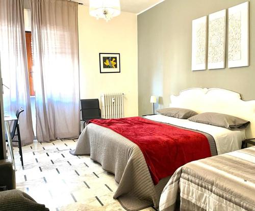 塔兰托罗莎德翁蒂住宿加早餐酒店的一间卧室配有两张床和红色毯子