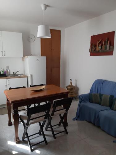 福萨切西亚Casa Titti. Intero Appartamento - Fossacesia的客厅配有桌子和蓝色沙发