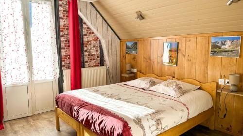 科特雷Hôtel Le Pas de L'Ours的一间卧室配有一张带红色窗帘的床