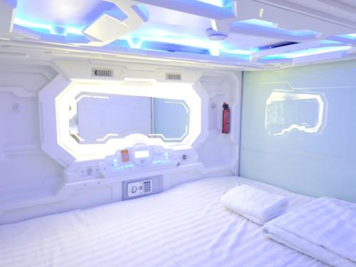 胡志明市Capsule Riverside的一间卧室配有一张床和一台位于走廊的电视