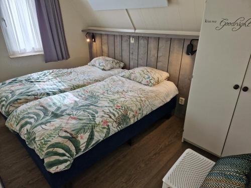 GramsbergenGezellig vakantiehuis 't Gramsbergje的一间卧室配有一张床和被子