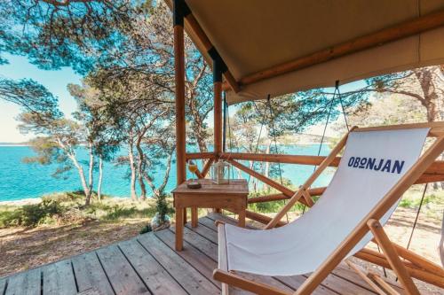 希贝尼克Obonjan Island Resort的甲板上的摇椅,背靠大海