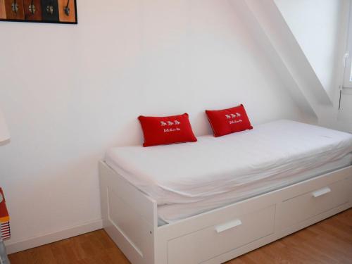 勒帕莱Maison Le Palais, 3 pièces, 4 personnes - FR-1-418-220的一张带两个红色枕头的白色床