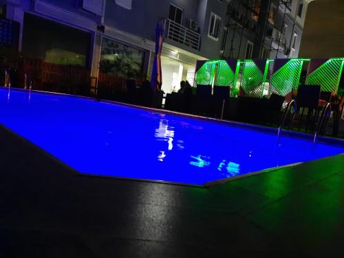 莱基James Court Hotel & Luxury Apartments的夜间游泳池,拥有蓝色照明