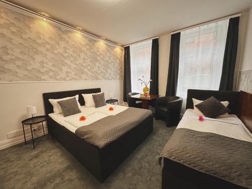 汉堡Hotel Nord的酒店客房,配有两张床和椅子