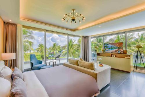 岘港Deluxe Beach Villas by Danatrip的一间卧室设有一张大床和一个大窗户
