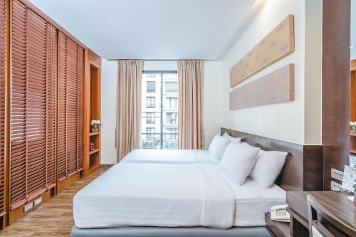 曼谷于拉查达阿曼塔酒店的一间卧室设有一张床和一个大窗户