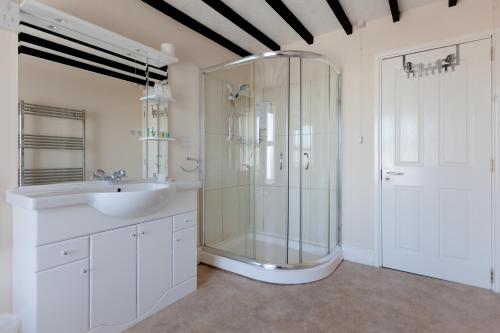廷塔杰尔亚瑟王阿姆斯宾馆的一间带玻璃淋浴和水槽的浴室