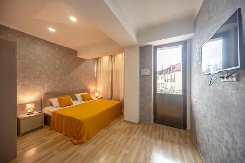 茨卡尔图博Tskaltubo Hotel Terrace的一间卧室设有黄色的床和窗户。