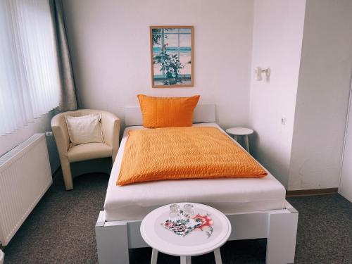 霍恩-巴特迈恩贝格科内酒店的一间卧室配有一张带橙色毯子和桌子的床