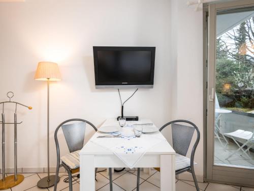特拉本特拉巴赫Apartment An der Mosel by Interhome的一张带椅子的白色桌子和墙上的电视