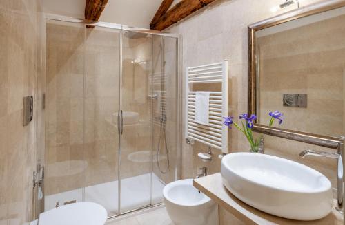威尼斯Maison Venezia | UNA Esperienze的浴室配有白色水槽和淋浴。