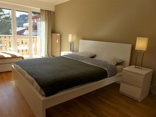 克莱恩 蒙塔纳Apartment Clavan by Interhome的一间卧室设有一张大床和一个大窗户