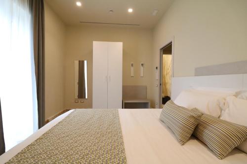 马瑞纳迪卡拉拉Doride Suites Boutique Hotel的卧室配有一张带两个枕头的大白色床