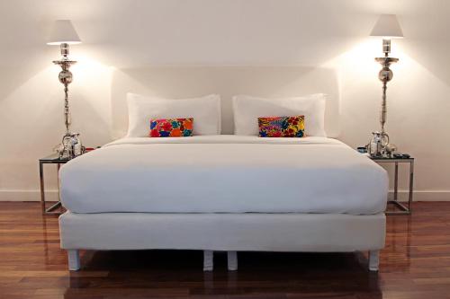 普埃布拉Palacio Julio Hotel的卧室配有带两盏灯的白色床