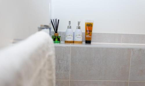 米尔顿凯恩斯Luxurious MK Apartment-Campbell Park的浴室里的一个架子,有三个洗发水瓶子