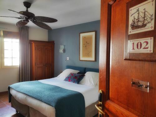 圣让-德吕兹Hôtel La Marisa Grande Plage的一间卧室配有一张床和吊扇